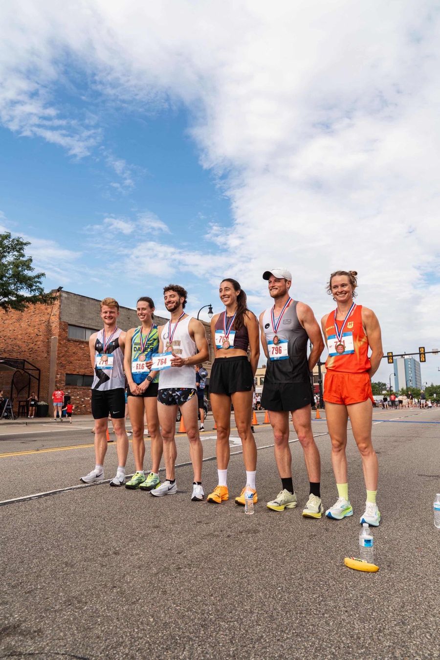 Medallists lined up after a July 4th road race, including a Runline athlete